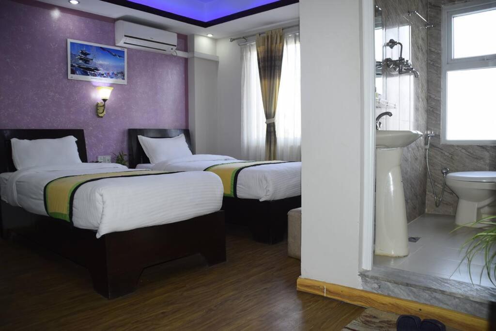 a hotel room with two beds and a sink at two-bed room in Thamel, peaceful location Kathmandu in Kathmandu