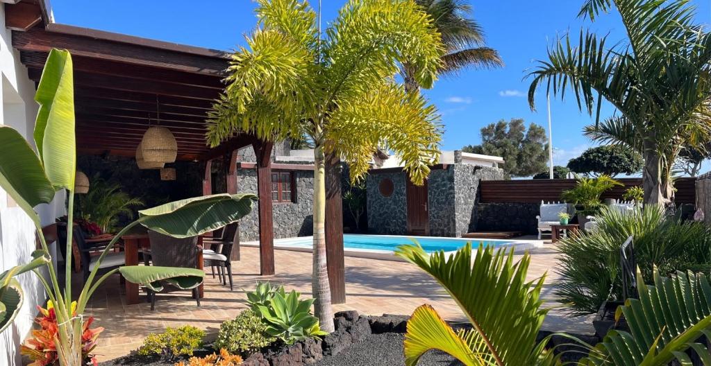a villa with a swimming pool and palm trees at Casa Chic Lanzarote in Puerto del Carmen