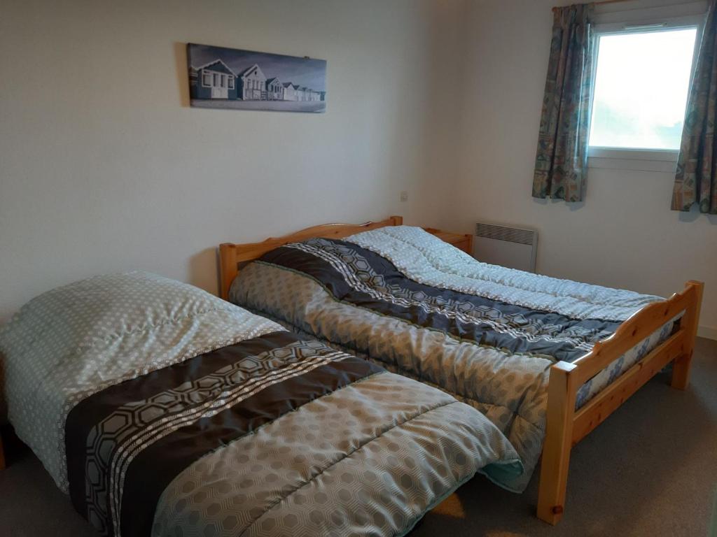 two twin beds in a room with a window at Maison Jard-sur-Mer, 3 pièces, 5 personnes - FR-1-485-78 in Jard-sur-Mer