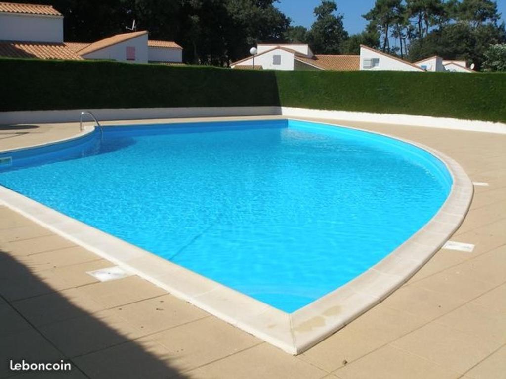 a large blue swimming pool in a yard at Maison Jard-sur-Mer, 3 pièces, 5 personnes - FR-1-485-78 in Jard-sur-Mer