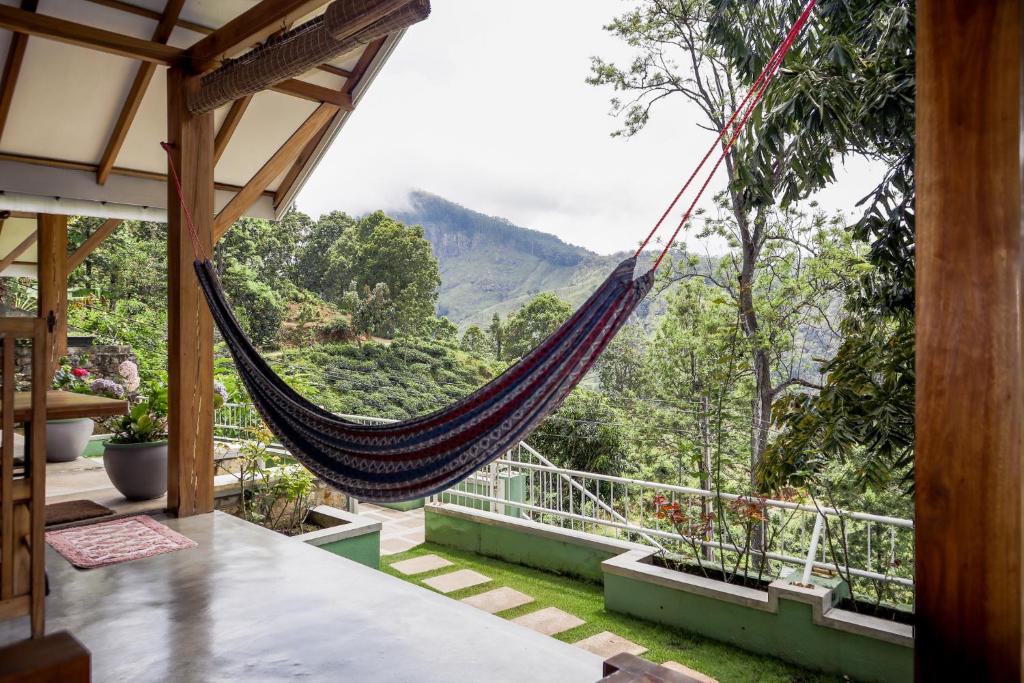 a hammock in a house with a view of the mountains at The One Ella in Ella