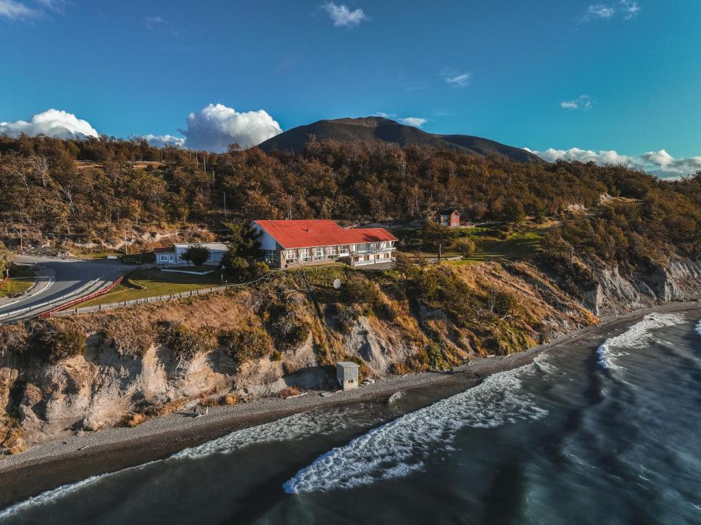 a house on a cliff next to the ocean at Hosteria Kaiken in Tolhuin