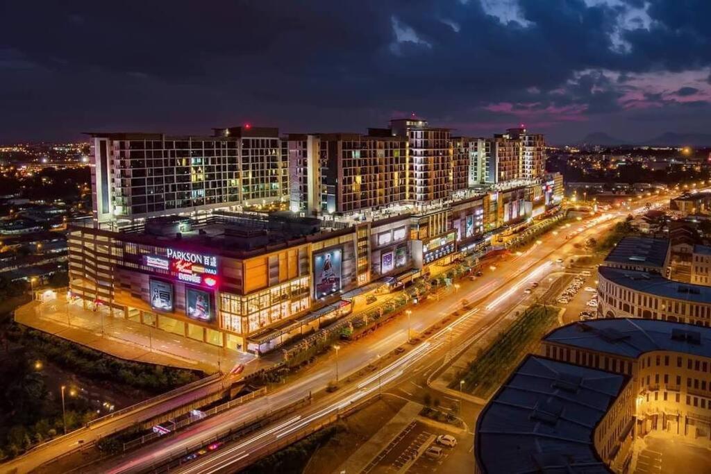 uma cidade iluminada à noite com edifícios e tráfego em H. S. Tang's Homestay J1 em Kuching