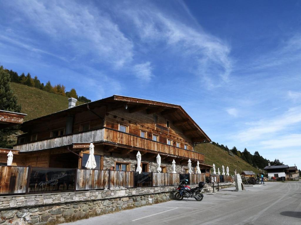 a wooden building with a motorcycle parked in front of it at Chalet in Zillertal near Hochzillertal Ski Area in Zellberg