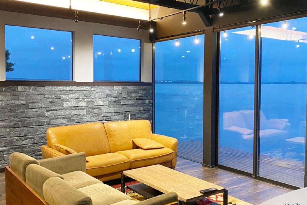 三沢市的住宿－Tiny resort misawa，客厅设有黄色的沙发和窗户。