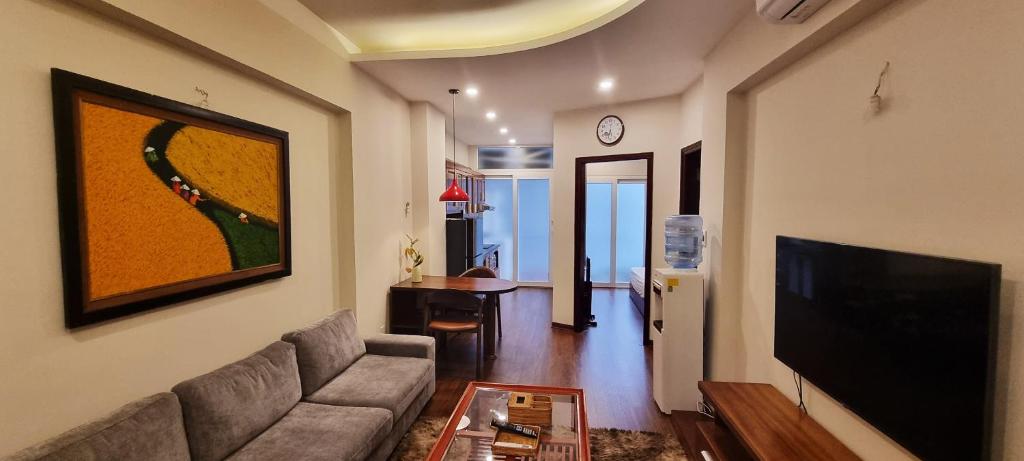 a living room with a couch and a flat screen tv at Ruby Serviced Apartment Liễu Giai in Hanoi
