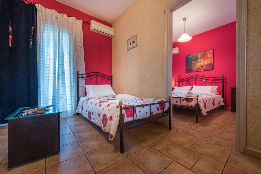 a bedroom with two beds and red walls at Pansion Porto Tsi Ostrias in Keri