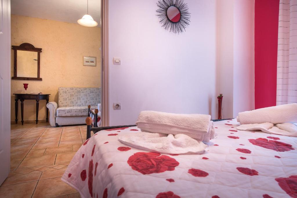 a bedroom with a bed with red flowers on it at Pansion Porto Tsi Ostrias in Keri