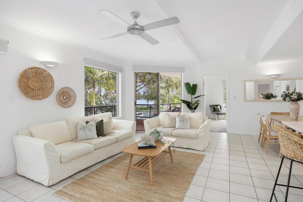 a living room with two white couches and a table at Como Noosa in Noosaville