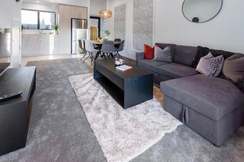 sala de estar con sofá y mesa en Modern 3 bed overlooking Hagley Park, en Christchurch
