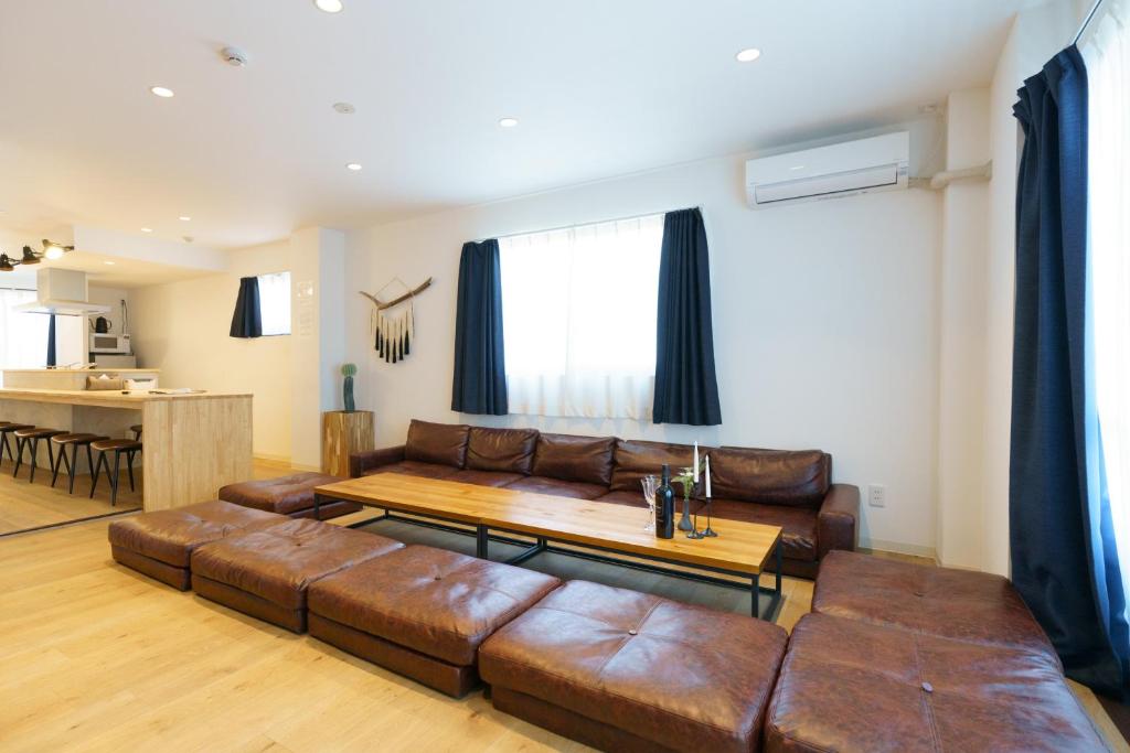 sala de estar con sofá marrón y mesa en 自由自在OSU 501(SORA), en Nagoya