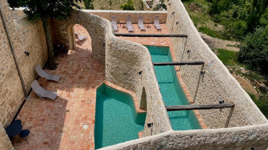 an overhead view of a swimming pool with chairs at Hotel Village Balatura - exclusive VEGGIE in Tribalj