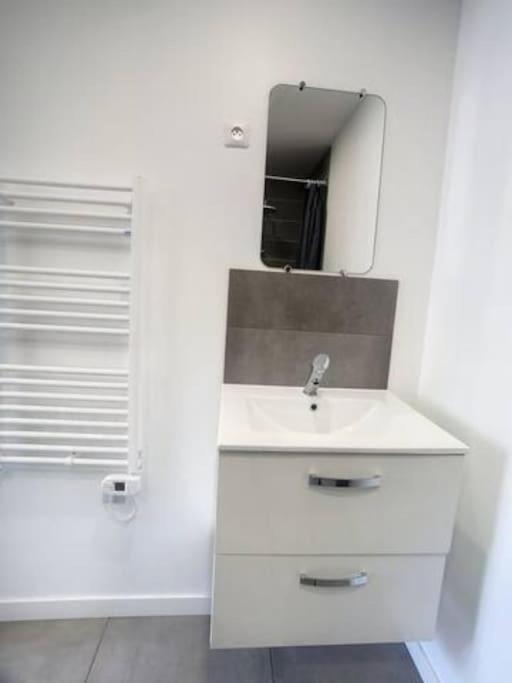biała łazienka z umywalką i lustrem w obiekcie SUPER Studio Tout équipé WIFI 2PERS w mieście Saint-Quentin