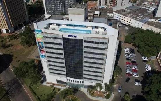a large white building with a pool in a city at Unidade Executiva Luxo 33m² in Brasilia