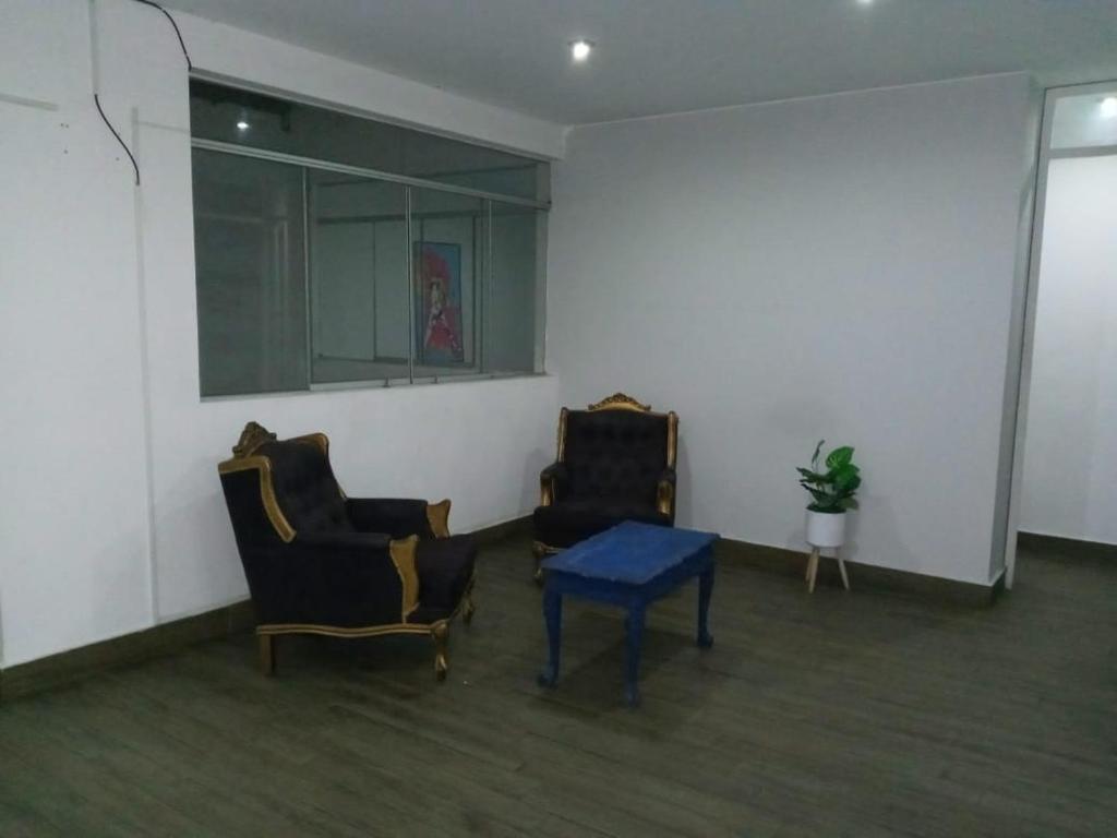 Habitación con 2 sillas y mesa azul en Depa Los condores La Molina, en La Molina