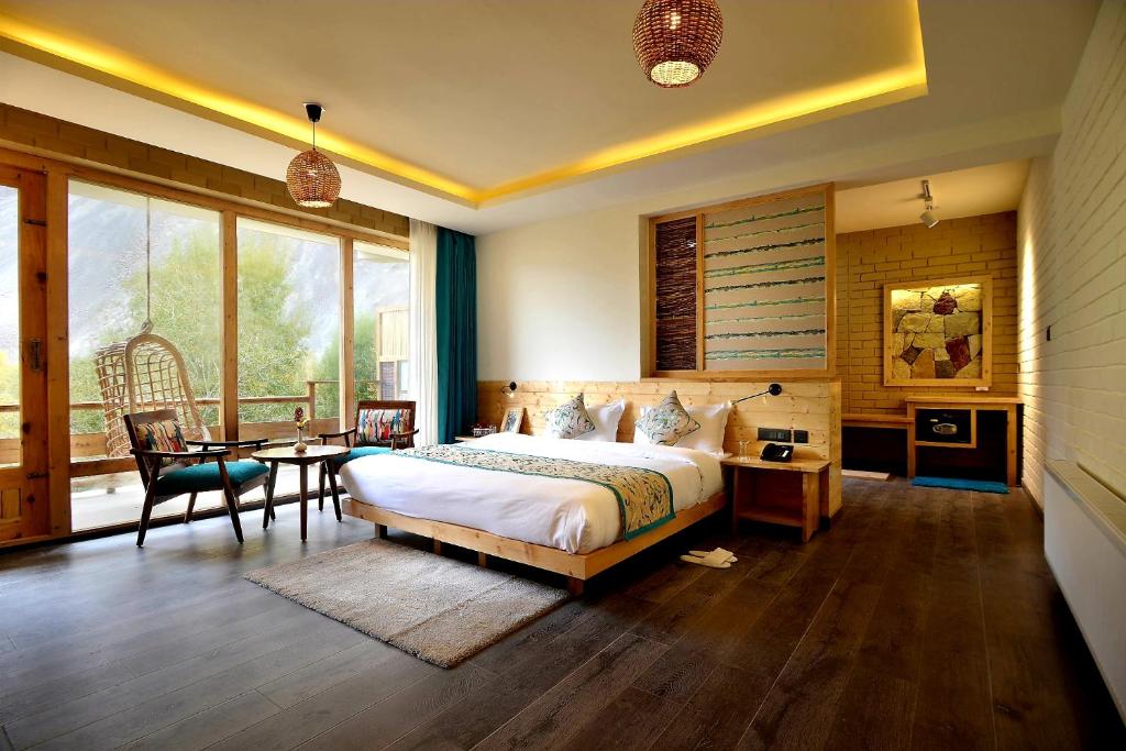 um quarto com uma cama, uma mesa e cadeiras em Stone Hedge Hotel em Vale de Nubra