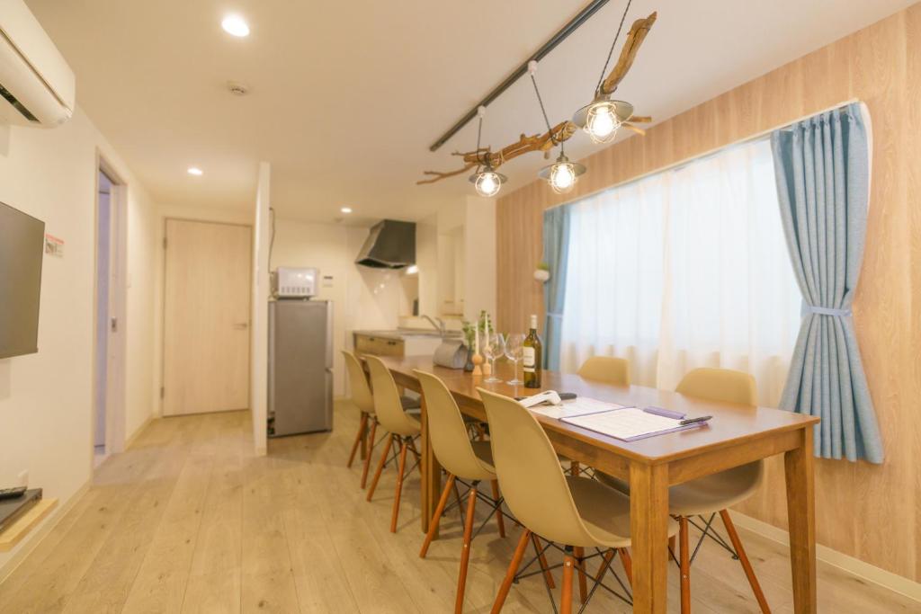 - une cuisine et une salle à manger avec une table et des chaises dans l'établissement 自由自在OSU 202(UMI), à Nagoya