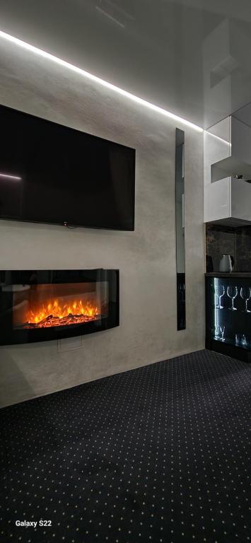 比亞韋斯托克的住宿－Chill LUX，客厅设有壁炉,墙上配有电视