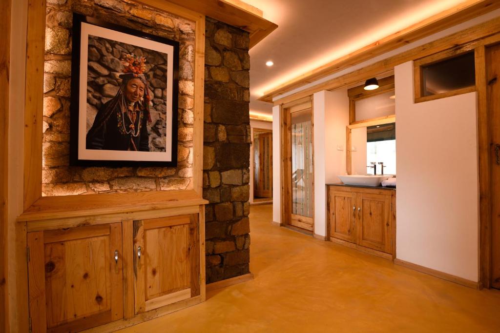 a bathroom with a painting on a stone wall at Stone Hedge Hotel in Nubra
