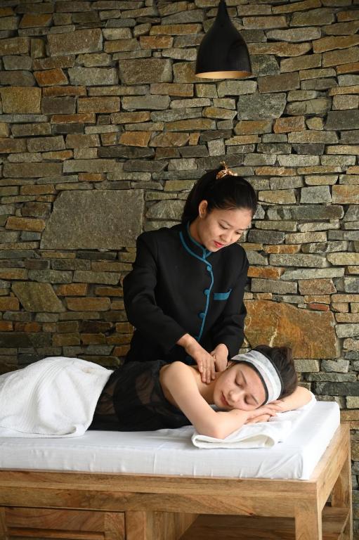 a woman sitting on top of a woman on a mattress at Stone Hedge Hotel in Nubra