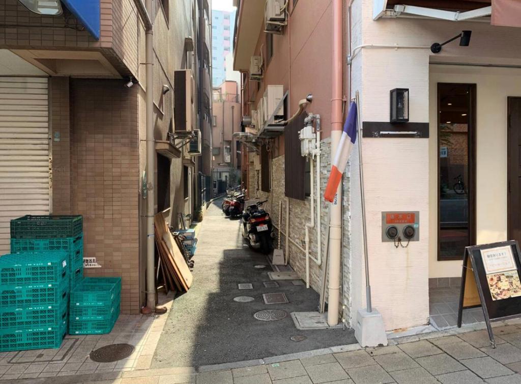 un callejón con una motocicleta estacionada al lado de un edificio en 14名まで宿泊可能！　交通至便！　Sannomiya Base 2 en Kobe