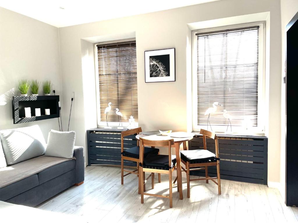a living room with a couch and a table and chairs at Apartament Kaja in Siemianowice Śląskie