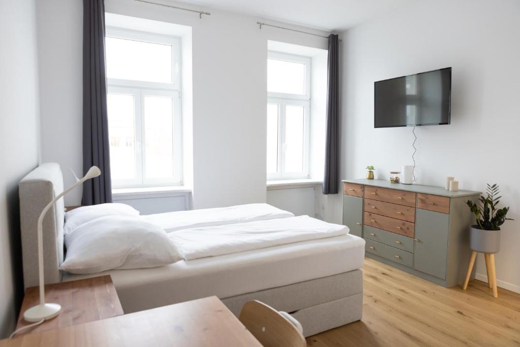 um quarto com uma cama e uma cómoda com uma televisão em DS Apartment 5 em Viena