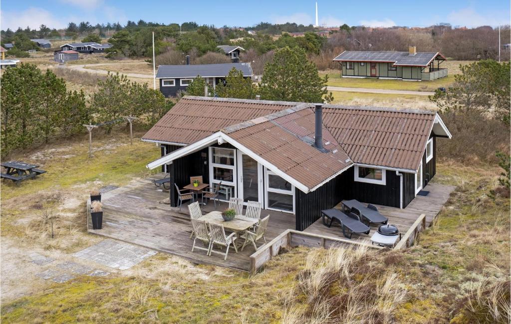 Cette chambre offre une vue sur une petite maison dotée d'une terrasse. dans l'établissement Beautiful Home In Fan With House A Panoramic View, à Fanø