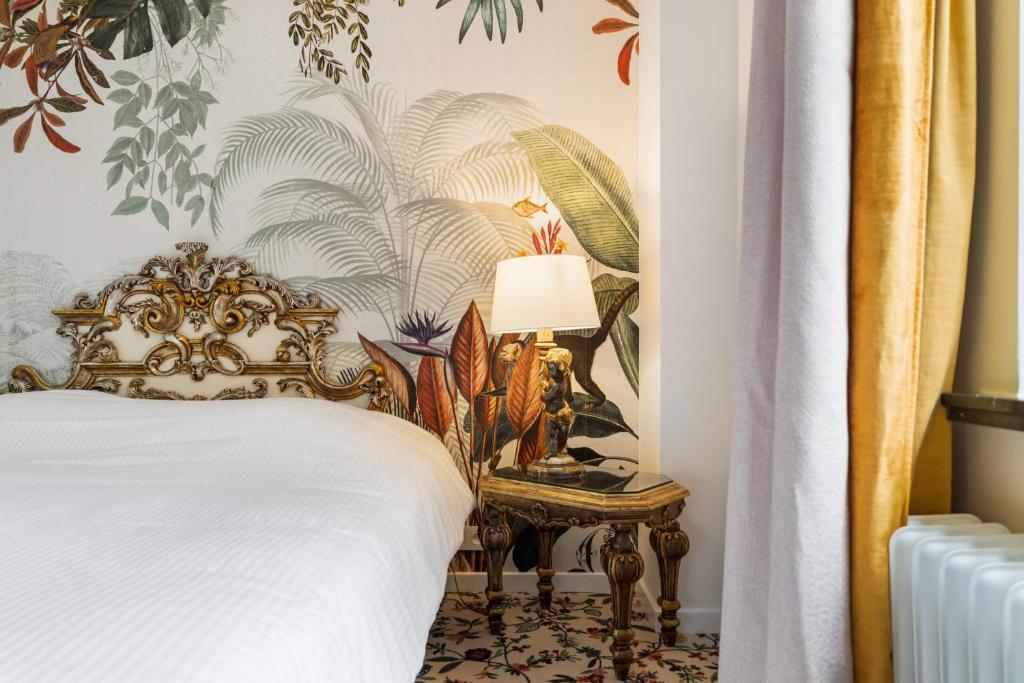 a bedroom with a bed and a table with a lamp at Hotel Torenhof in Sint-Martens-Latem