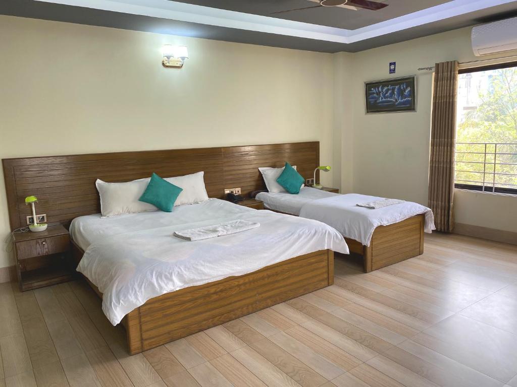 Habitación de hotel con 2 camas y ventana en Hotel River View, en Sylhet