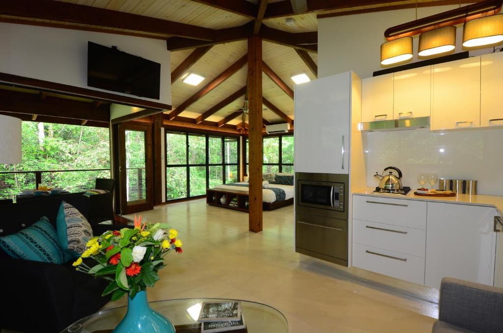 a kitchen and living room with a vase of flowers at Black Palm Cape Tribulation in Cape Tribulation
