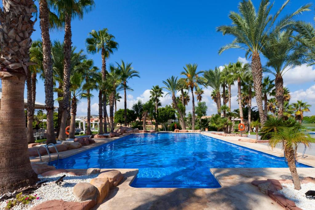アリカンテにあるHotel Alicante Golfのリゾート内のヤシの木があるスイミングプール