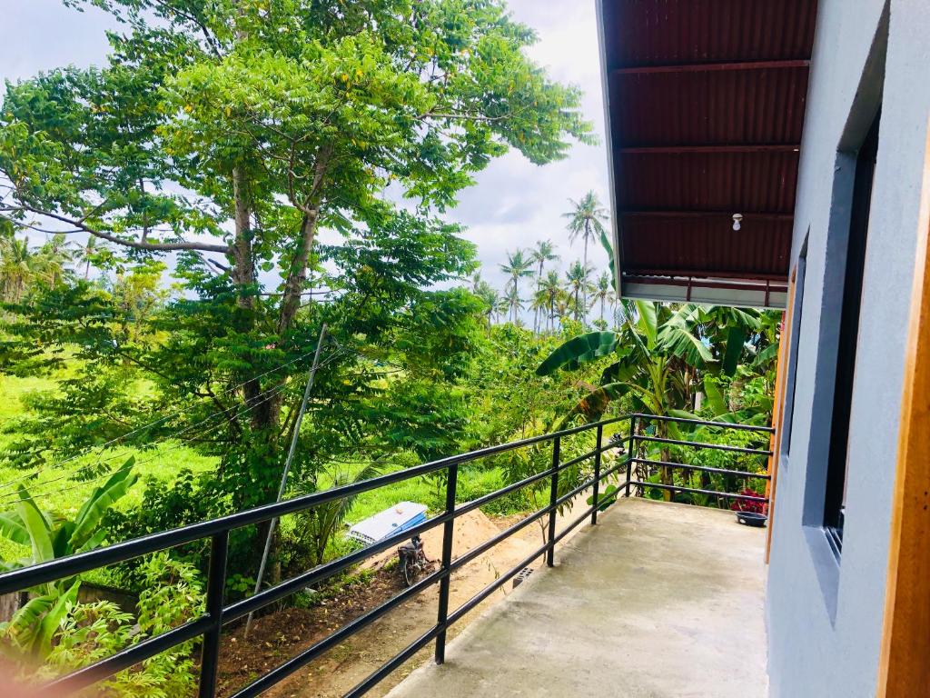 a balcony with a view of a forest at RedDot Guest House in General Luna