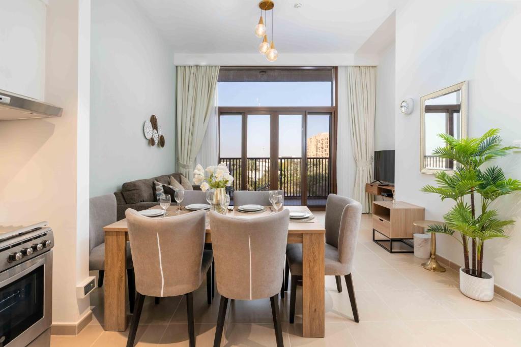 Town Square في دبي: غرفة طعام وغرفة معيشة مع طاولة وكراسي