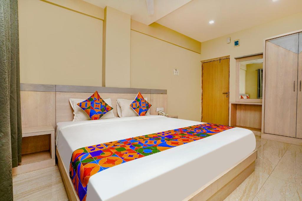 a bedroom with a large bed with a colorful blanket at FabHotel Bhiwandi Palace in Mumbai