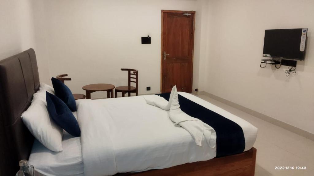 a bedroom with a white bed with blue pillows at Wanderers Howff in Port Blair