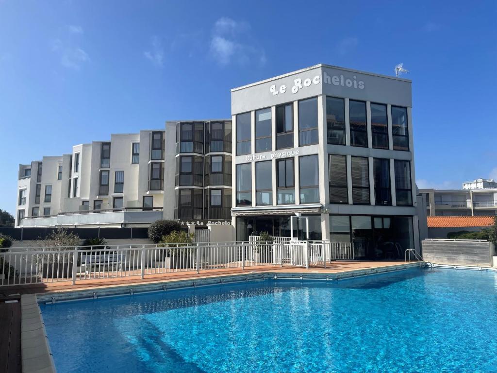 a building with a swimming pool in front of a building at Logis Hôtel Le Rochelois in La Rochelle