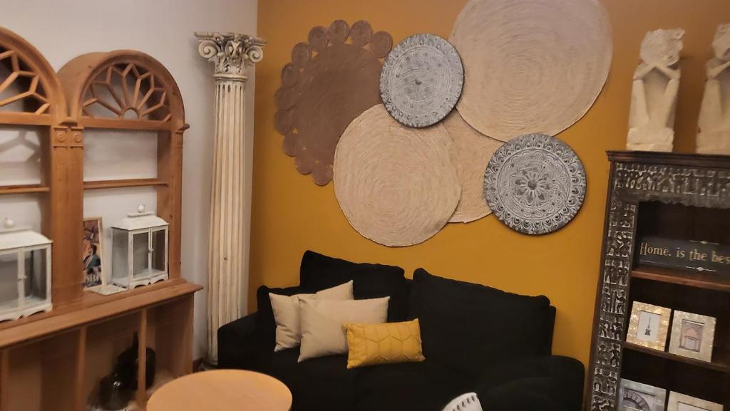 - un salon avec un canapé et des assiettes murales dans l'établissement APARTAMENTO CASA NARANJO, à Cordoue