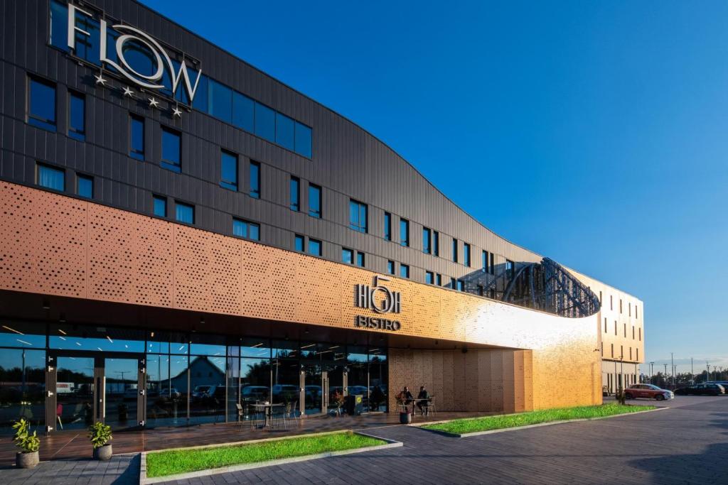 a building with a hilton hotel sign on it at Flow Hotel & Conference in Inárcs