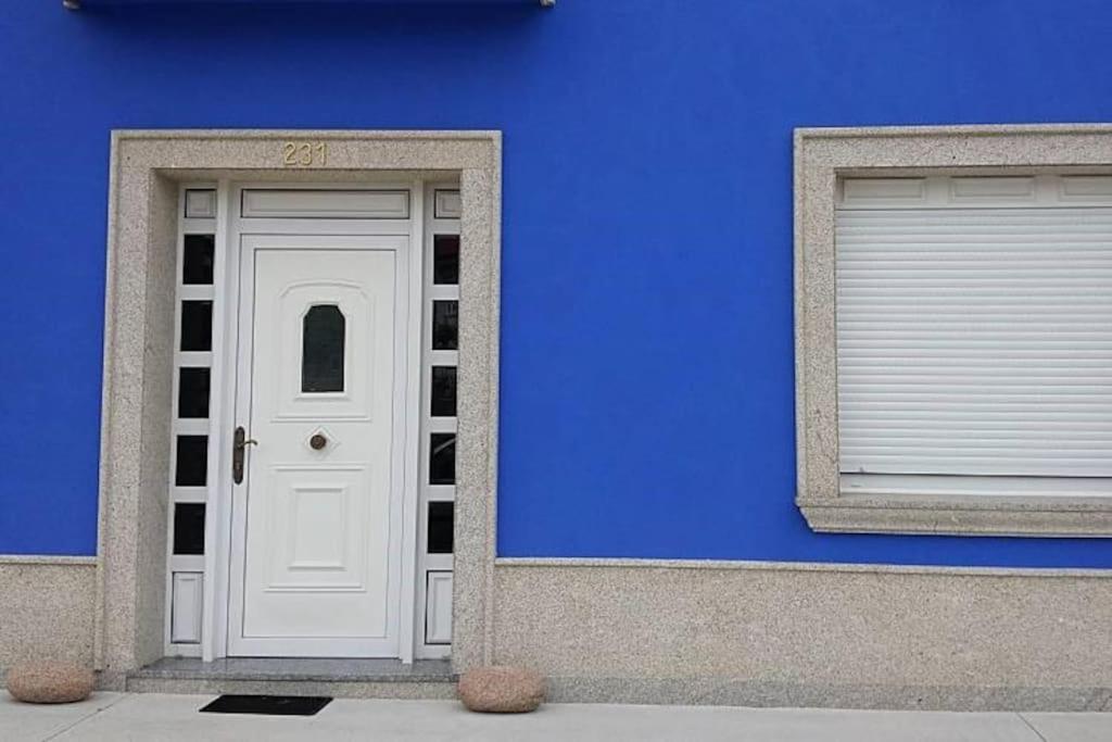 a blue building with a white door and a window at Apartamento de 2 habitaciones. in Dor