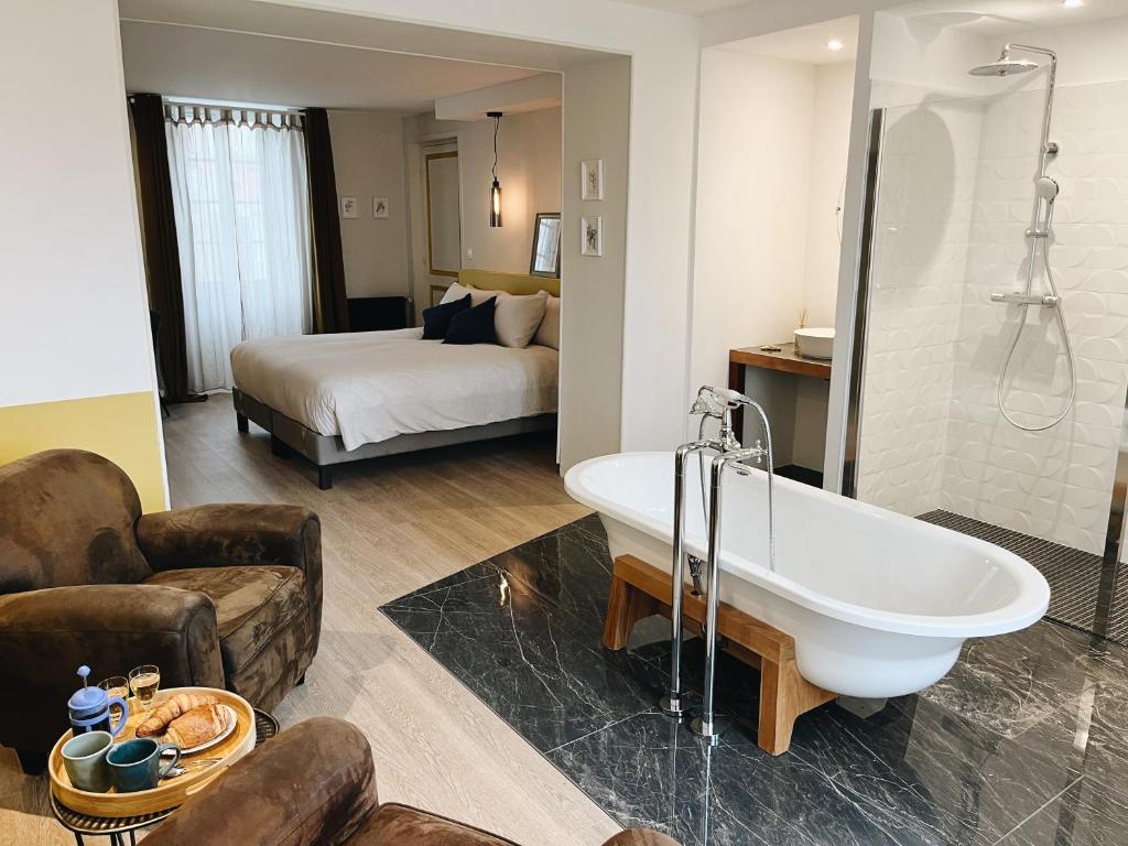 ein Badezimmer mit einer Badewanne und ein Schlafzimmer mit einem Bett in der Unterkunft Domaine Labouroume in Salies-de-Béarn