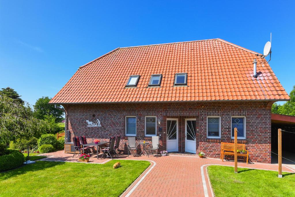 a brick house with an orange tile roof at Ferienwohnung Mühlenblick auf dem Ferienhof Eschen in Moorweg