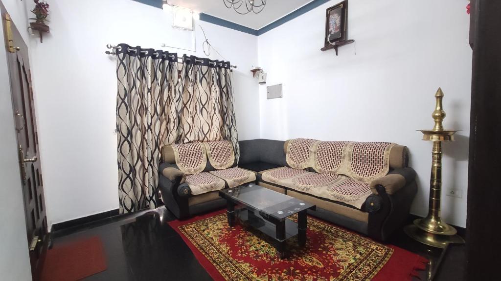 a living room with two chairs and a rug at Gokulam Holiday Home in Munnar