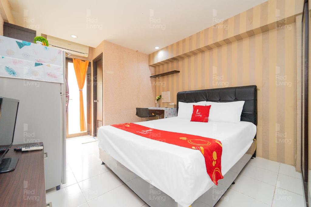 a bedroom with a large bed and a television at RedLiving Apartemen Kebagusan City - Nuna Rooms in Jakarta