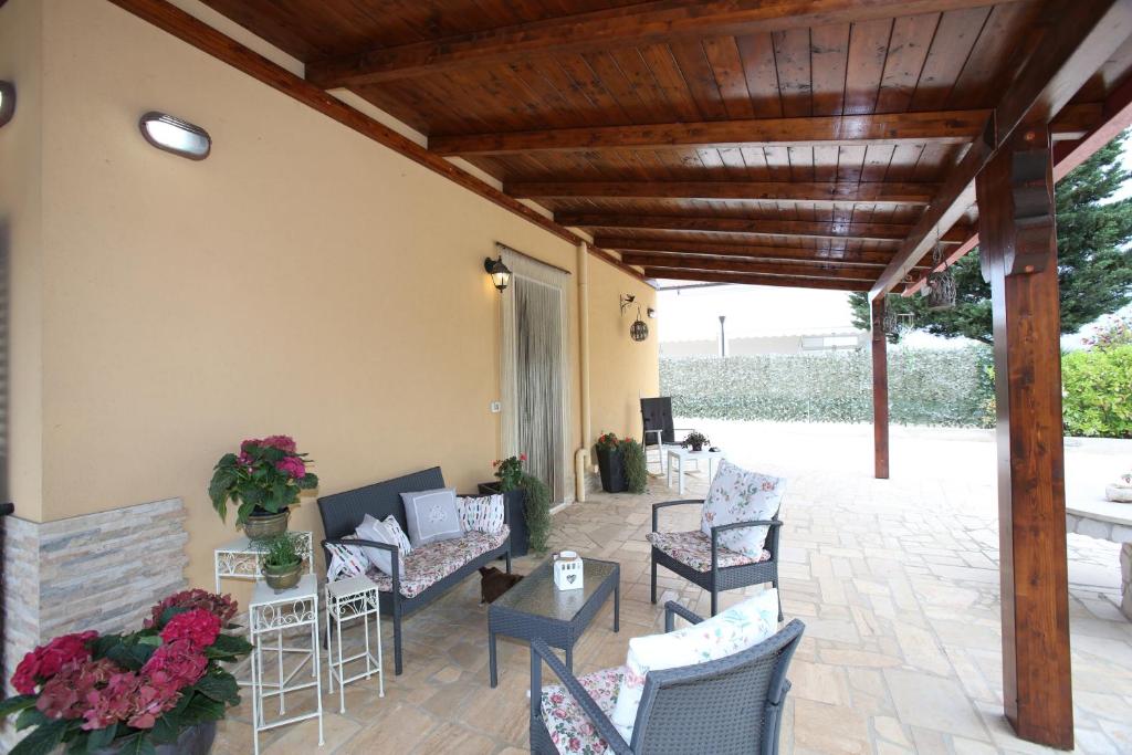 un patio con sedie, tavoli e soffitto in legno di A casa di Isor a San Vito dei Normanni