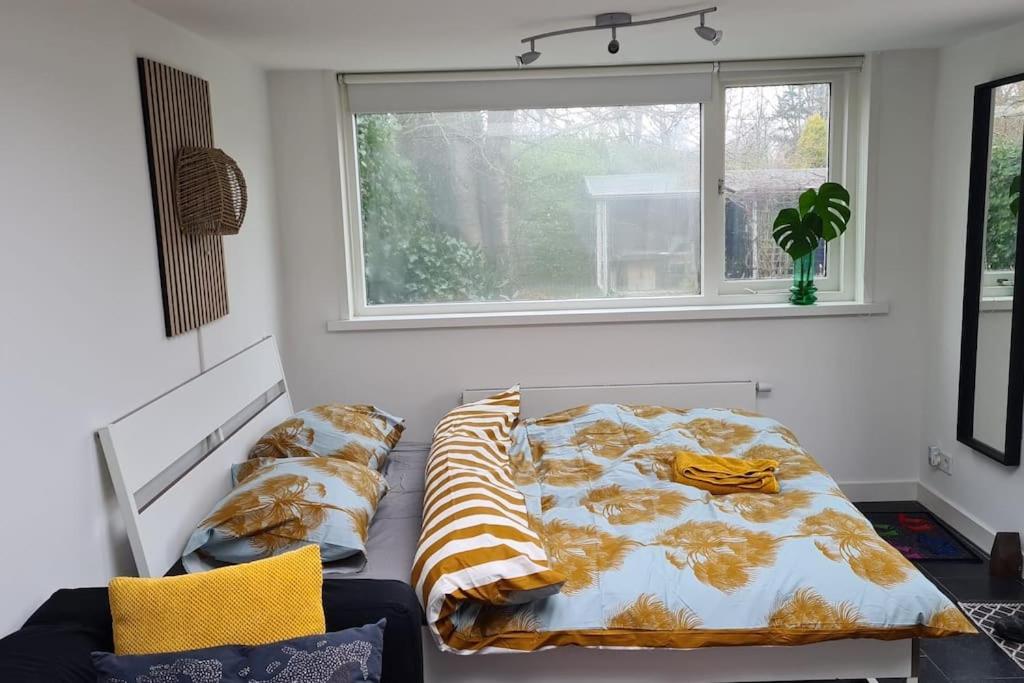 Tiny house Wassenaar في فاسينار: سرير جالس في غرفة مع نافذة