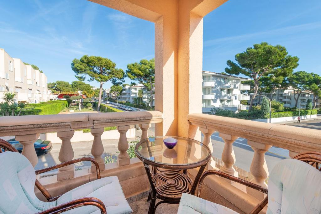 a balcony with chairs and a table and a view of a city at Casa Elena in Cala Ratjada