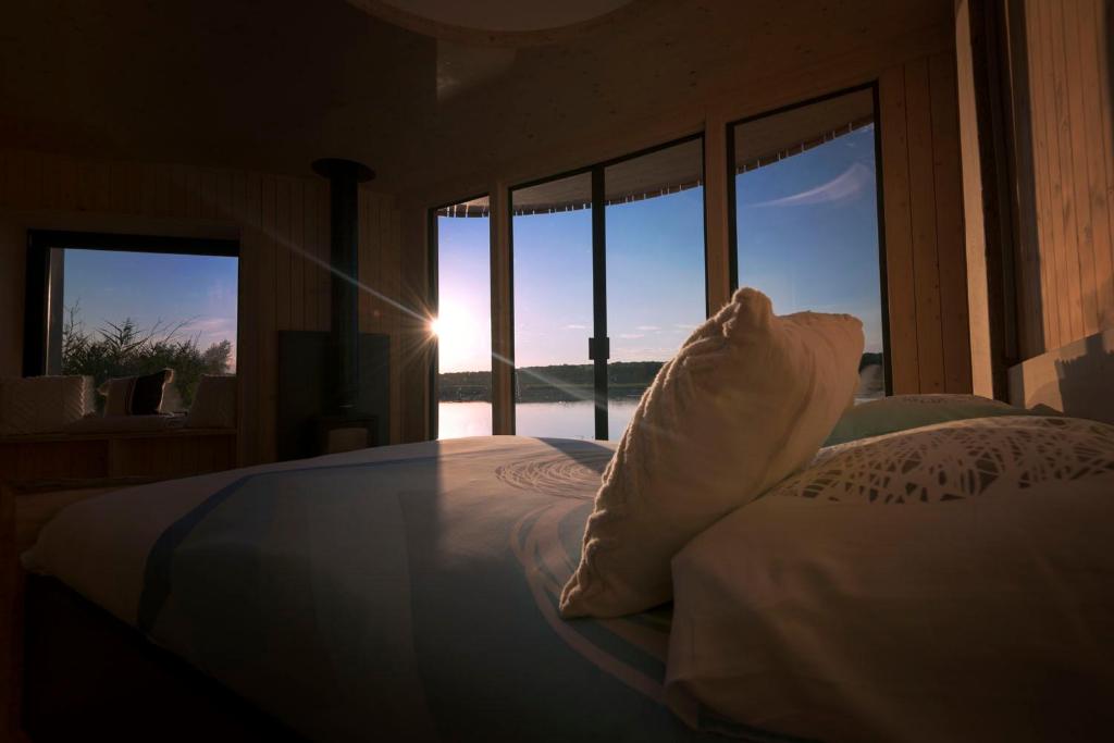 sypialnia z łóżkiem i widokiem na ocean w obiekcie Aquascope Virelles - Logements insolites w mieście Chimay