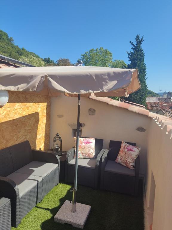 un patio con 2 sofás bajo una tienda en Duplex SERENITY, en Bédarieux