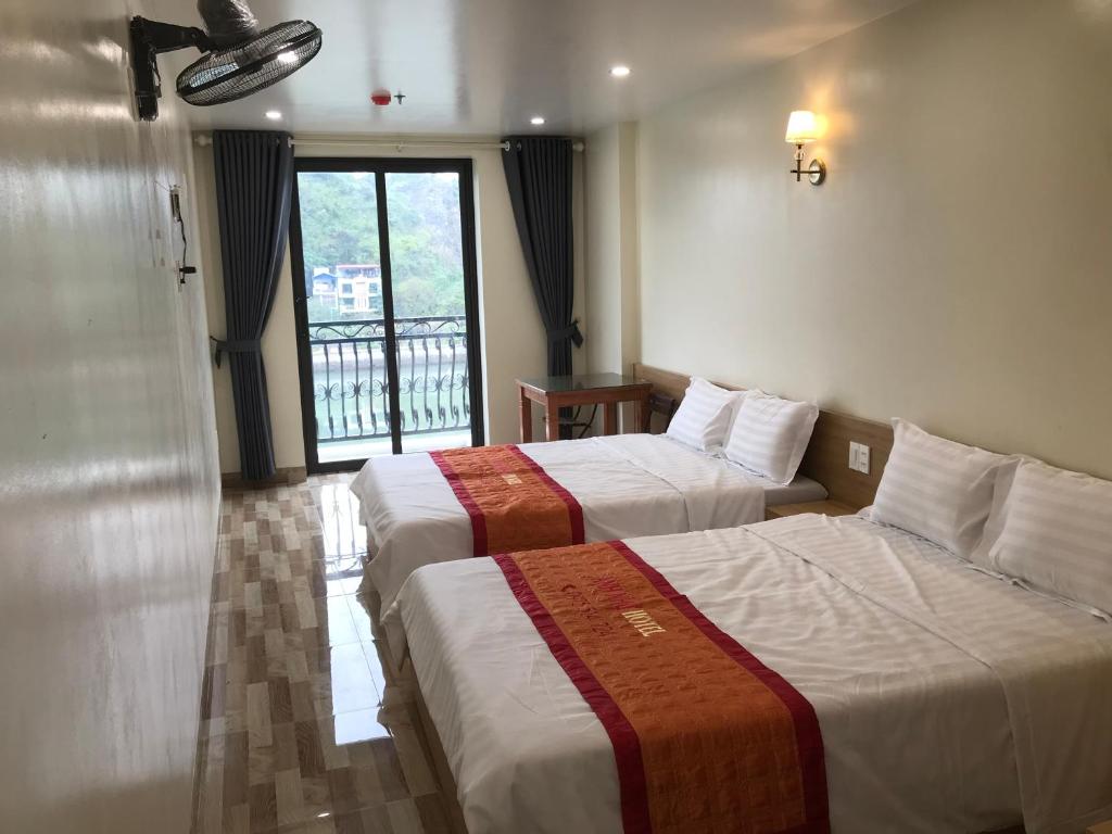 ein Hotelzimmer mit 2 Betten und einem Fenster in der Unterkunft Anh Nhu Hotel in Cát Bà